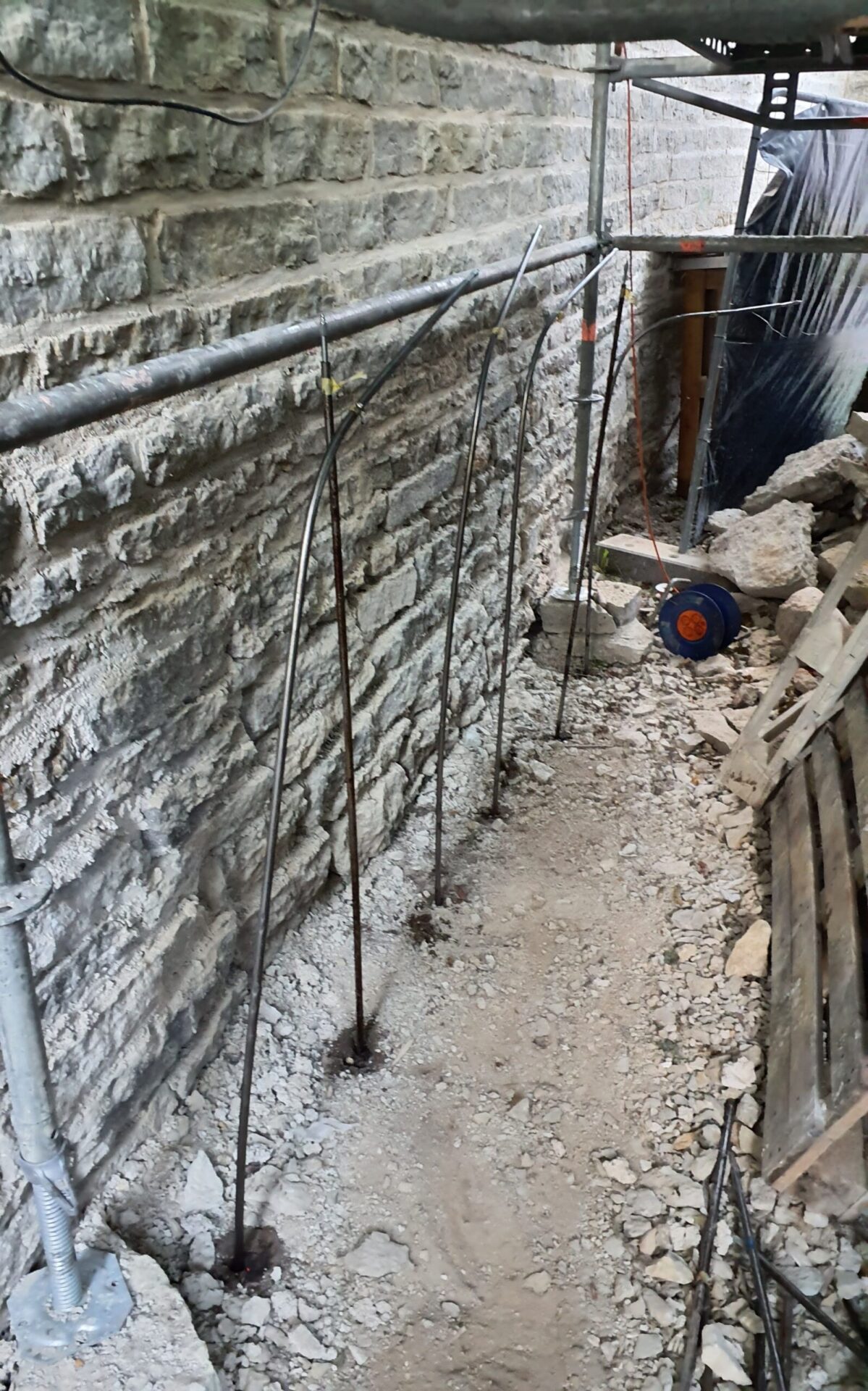 Controlled geopolymer injection setup along a historic masonry foundation for non-invasive soil stabilisation